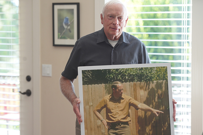 Elderly Vern holding photo of younger vern